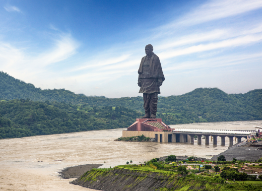 Statue of Unity surrounded by lush green landscapes and monsoon clouds in Kevadia.