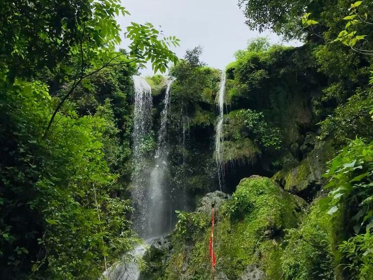 Hathni Mata Waterfall flowing at full force during monsoon near Pavagadh.